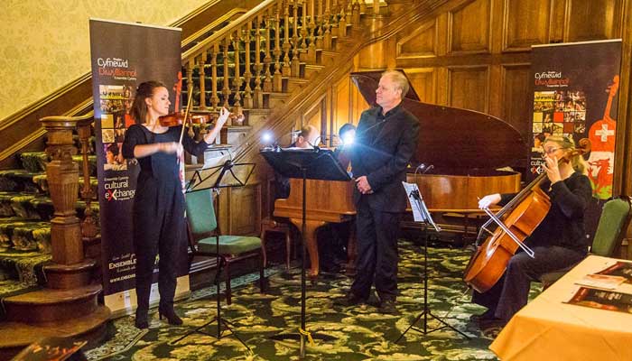 Live band performing inside Tre Ysgawen Hall, Anglesey, North Wales, with elegant decor and an enthusiastic audience