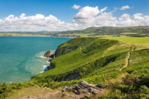 Pembrokeshire Coast with dramatic cliffs, sandy beaches, and clear blue sea in Wales