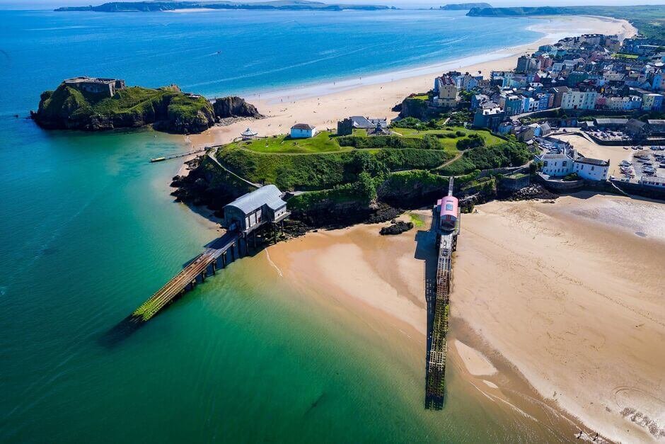 Tenby seaside town with colourful harbour houses, sandy beaches, and clear blue sea in Wales