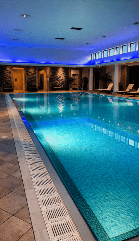 Indoor swimming pool at Tre-Ysgawen Hall Spa in Anglesey with relaxing ambient lighting