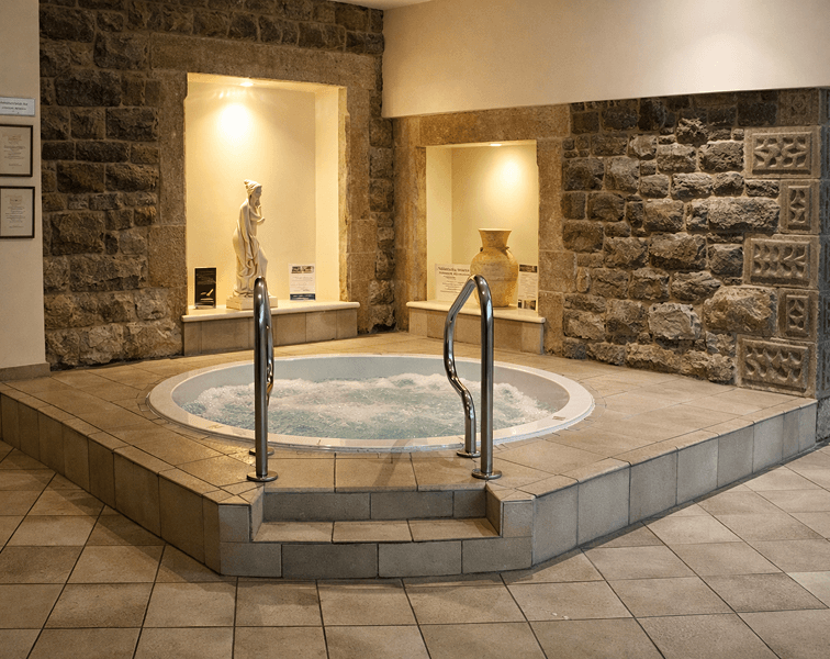 Luxury indoor Jacuzzi at Tre-Ysgawen Hall Hotel & Spa in Anglesey surrounded by traditional stone walls and relaxing spa facilities